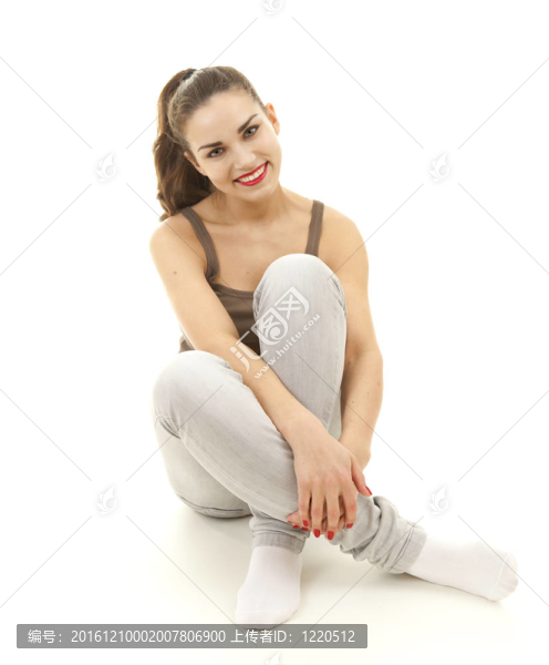 微笑的年輕女子盤腿坐著；白色背景