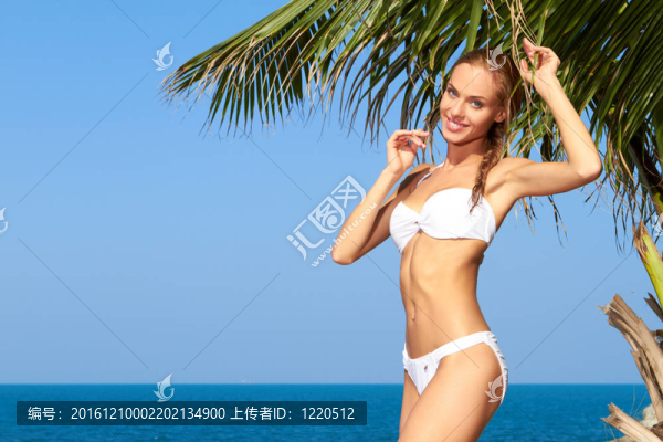 女孩在泳裝旁邊的棕櫚樹