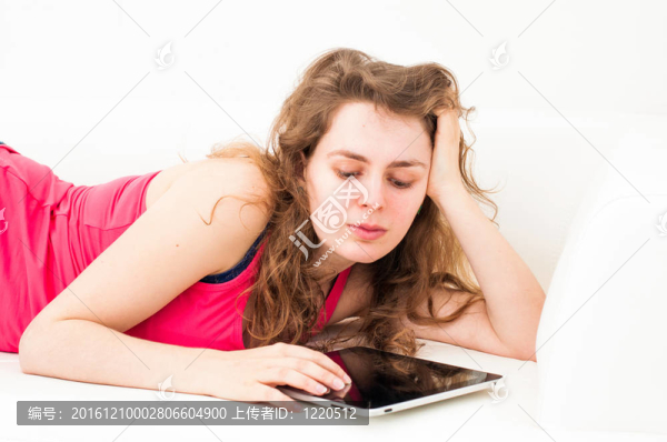 女子用觸摸屏平板電腦在沙發(fā)上