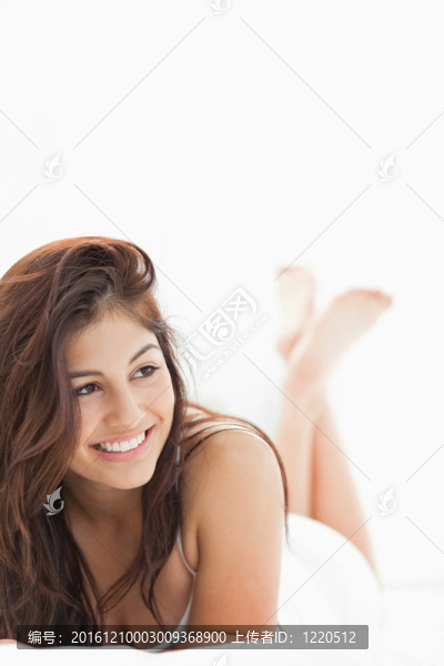 一個(gè)面帶微笑的女人特寫鏡頭，一邊看著一邊交叉雙腿。