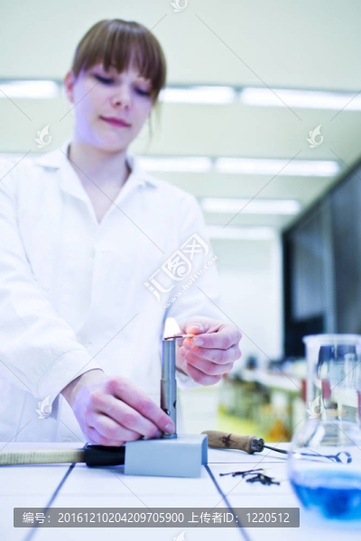 漂亮的年輕女研究員在實驗室里點燃了一根蠟燭