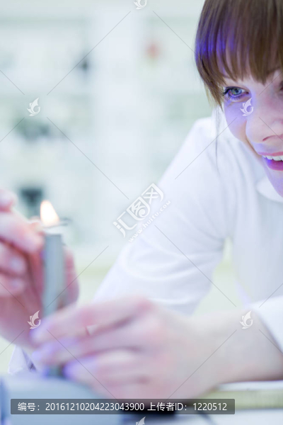 漂亮；年輕的女研究員點燃了一根火爐
