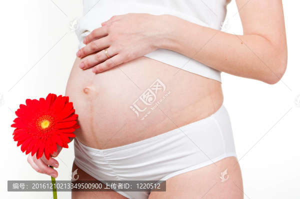 一個懷孕的女人牽著她的手在她的肚子和特寫