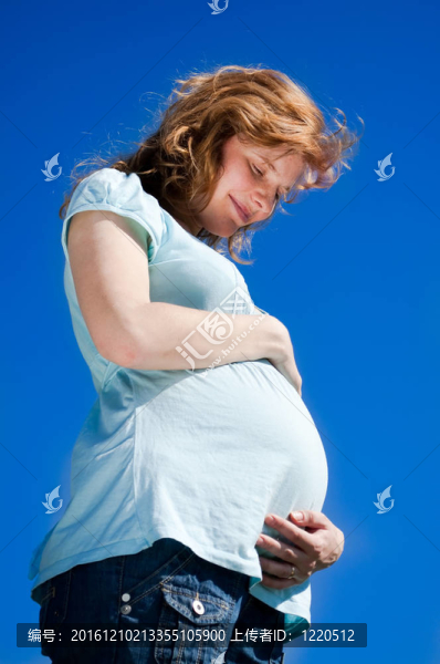 美麗的孕婦看著她的肚子