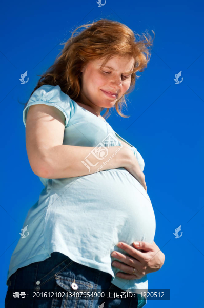 美麗的孕婦看著她的肚子