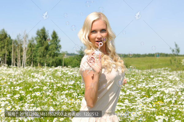 美麗的女人在草地上有泡沫