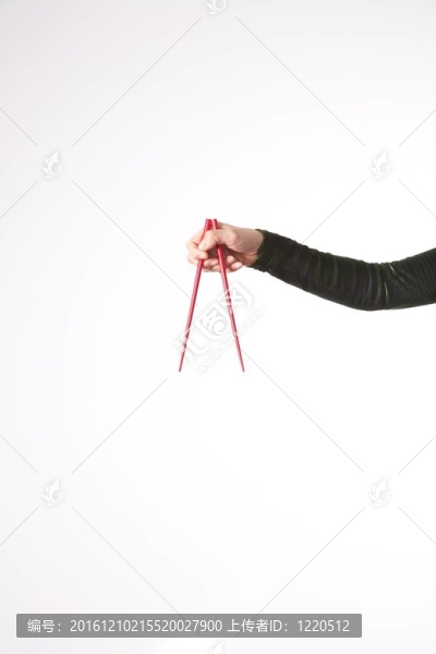 在白色背景上的紅色筷子孤立的女人的手了