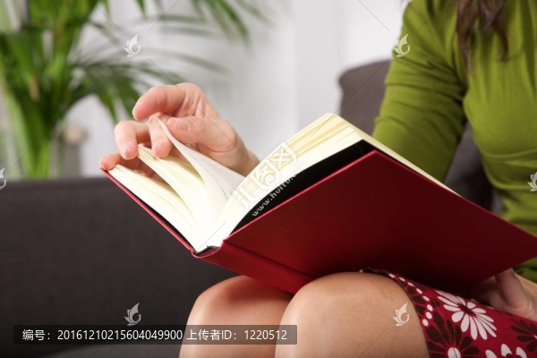 女人坐在棕色沙發(fā)上看書