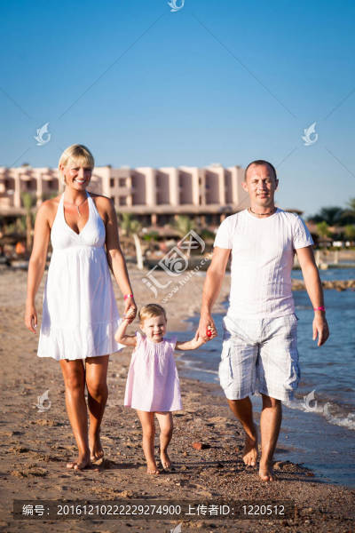 幸福的家庭在海滩散步