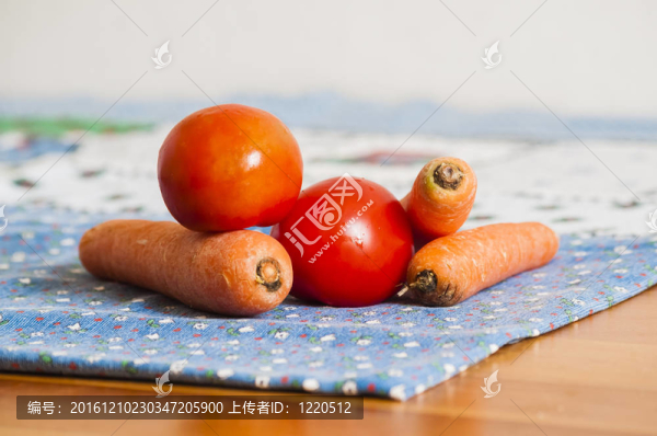 在藍色的桌布上西紅柿和胡蘿卜