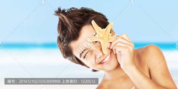 快樂的臉男孩與海星在海灘上