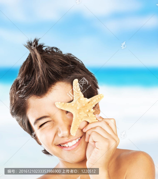 快樂的臉男孩與海星在海灘上