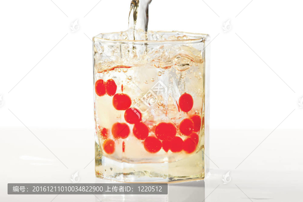 杯水；冰和紅色的越橘在黃燈閃