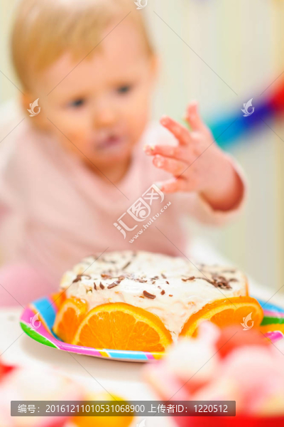 特寫在生日蛋糕和背景匿名吃抹上嬰兒