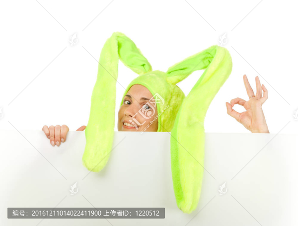 有趣的女孩在兔子服裝與空白板