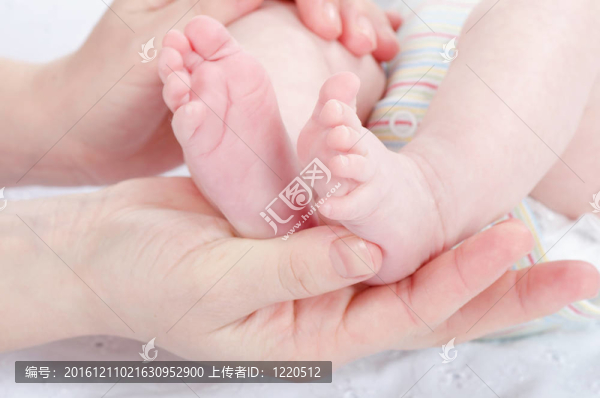 母親的手抱著嬰兒的腳