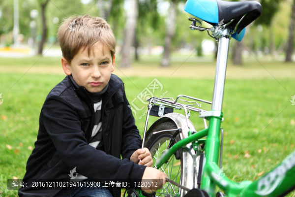 在綠色公園騎自行車的男孩