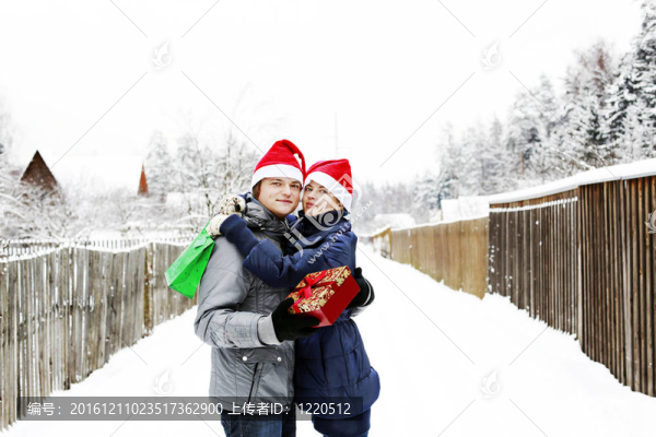 Santa帽子戶外送禮的年輕夫婦吸引人