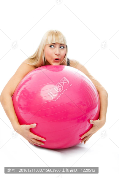 年輕金發(fā)女子擁抱健身球