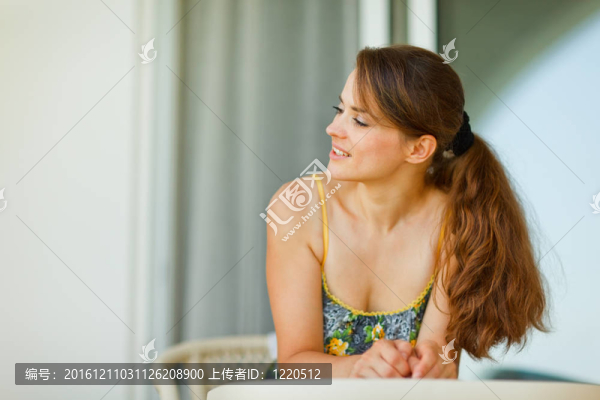 年輕女子坐在陽臺(tái)看分隔開的