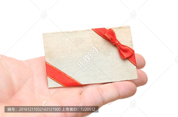 空白禮品標(biāo)簽與紅絲帶和弓在手舉行白色