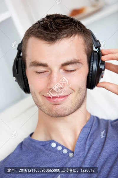 活潑的年輕人聽著音樂坐在客廳的沙發(fā)上