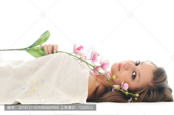 美麗的年輕女子面對花和毛巾