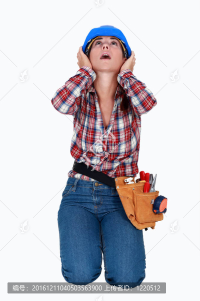 一名女建筑工人捂住耳朵。