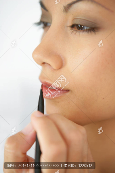 用鉛筆涂唇膏的女人