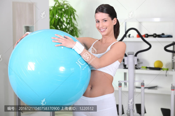 年輕女子拿著健身球