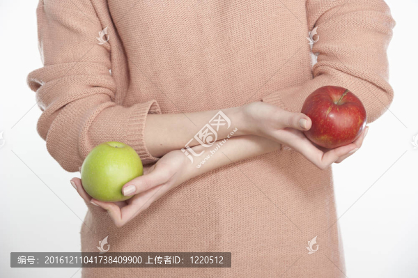 年輕女子拿著兩個蘋果