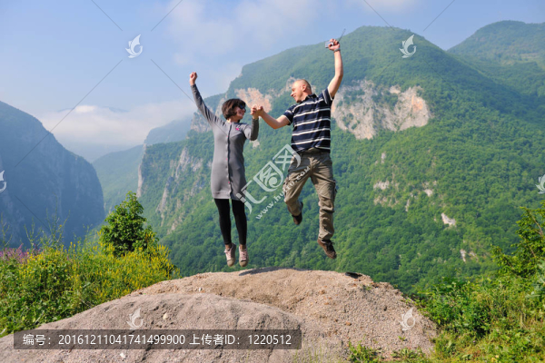 快樂的年輕情侶在空中跳躍