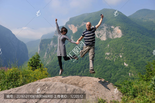 快樂(lè)的年輕情侶在空中跳躍