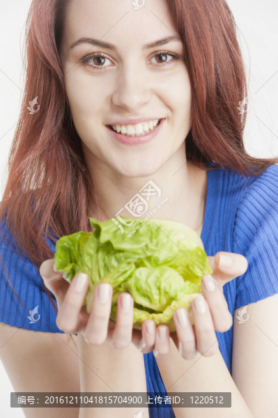 手里拿著萵苣的年輕女子