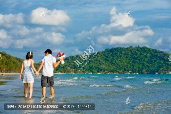 甜蜜的情侶走在最喜愛的沿著海灘的手