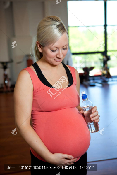 孕婦抱水瓶放松。