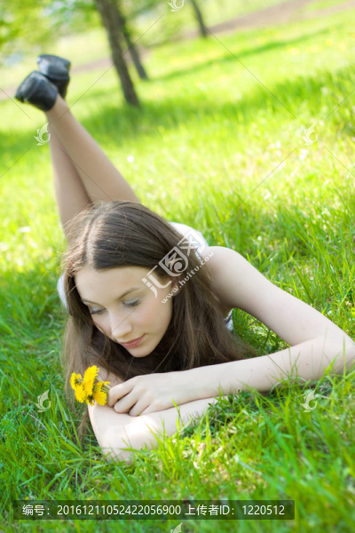 年輕美麗的少年與蒲公英在草坪上