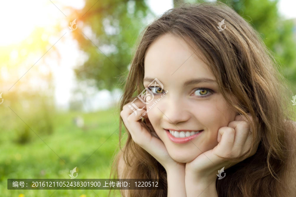 年輕的黑發(fā)少女微笑在草甸