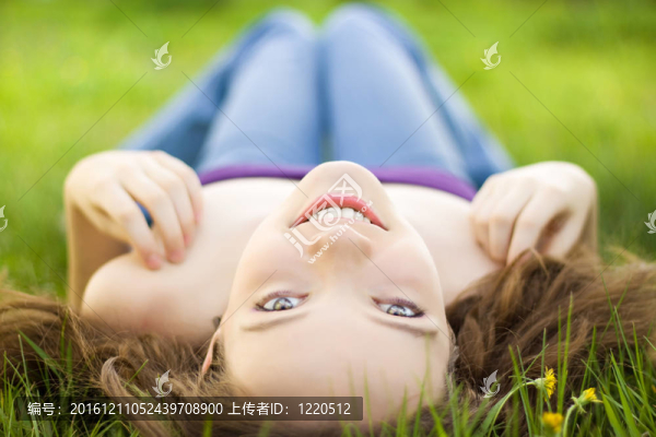 年輕的黑發(fā)少女微笑在草甸