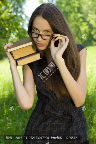 快樂(lè)的年輕女孩在公園里看書(shū)