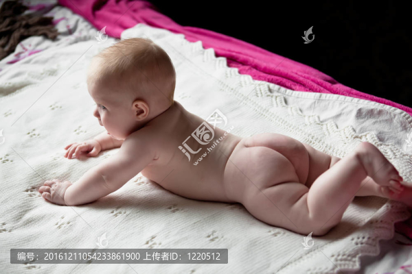 可愛的哭泣嬰兒躺在他的肚子沒有尿布