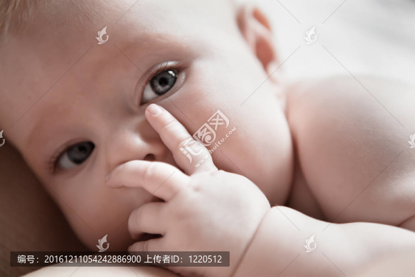 嬰兒躺在她母親的胸膛，閉上她的手掌