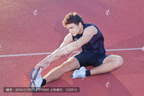 運動員在體育館慢跑后伸展身體。
