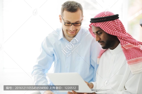阿拉伯語(yǔ)黑人和白人男子一起工作在筆記本電腦