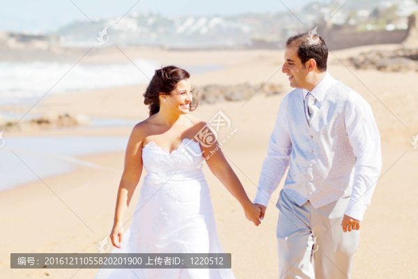 新婚夫婦在海灘散步