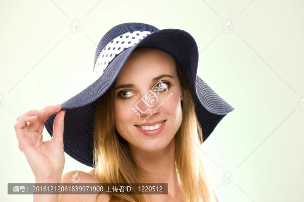 一個戴著淺綠色背景的夏帽的女人的肖像