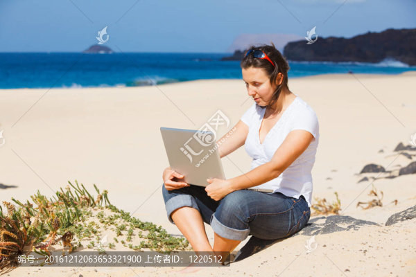海灘上的女人用筆記本電腦