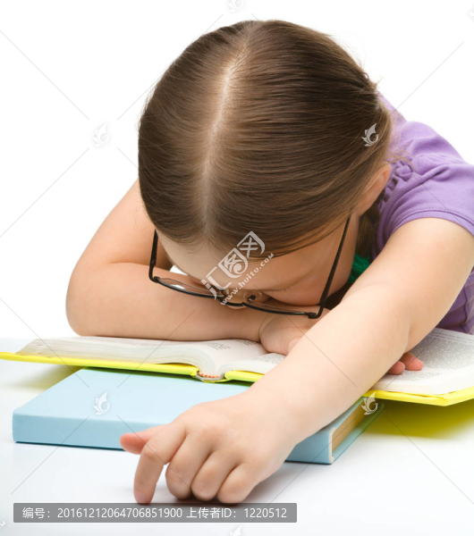 可愛的小女孩在書上睡覺
