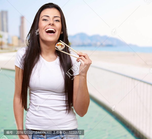 在海灘上舉行壽司的年輕女子肖像