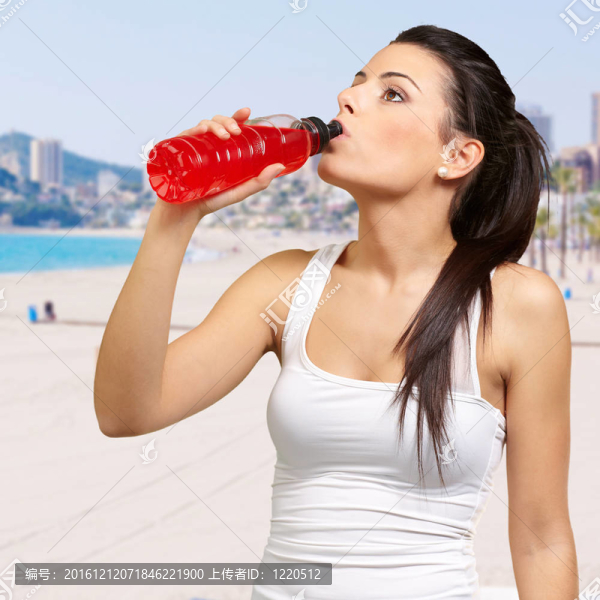對(duì)一個(gè)年輕女人的肖像運(yùn)動(dòng)飲用等滲飲料